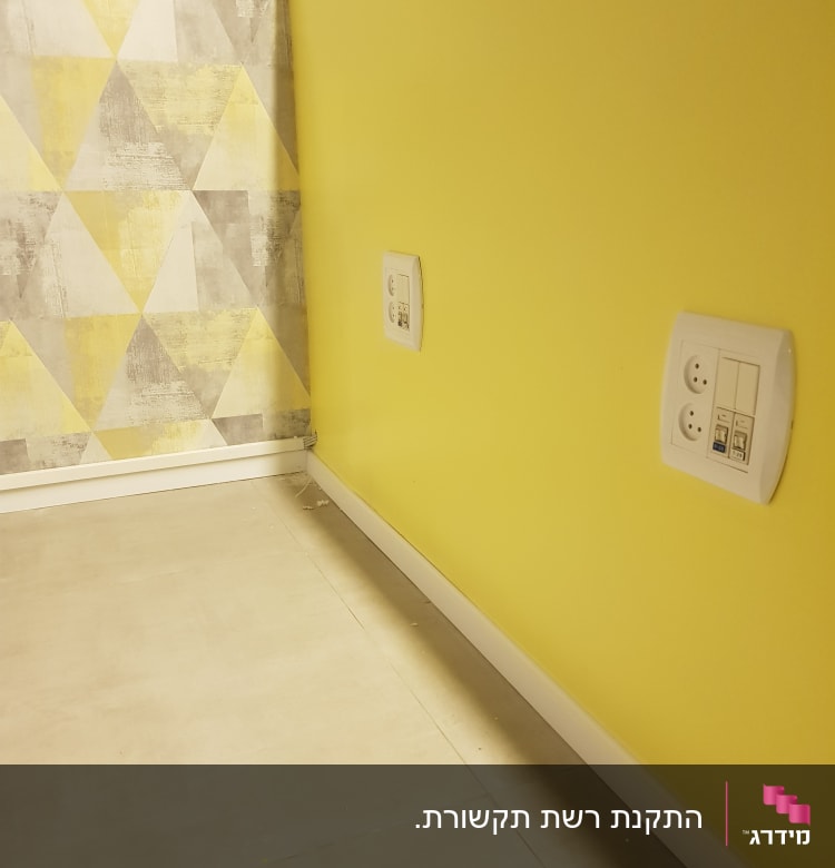שקעי חשמל ותקשורת על קיר צהוב